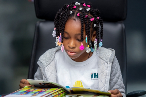 Child reading a book with IHS branding visible